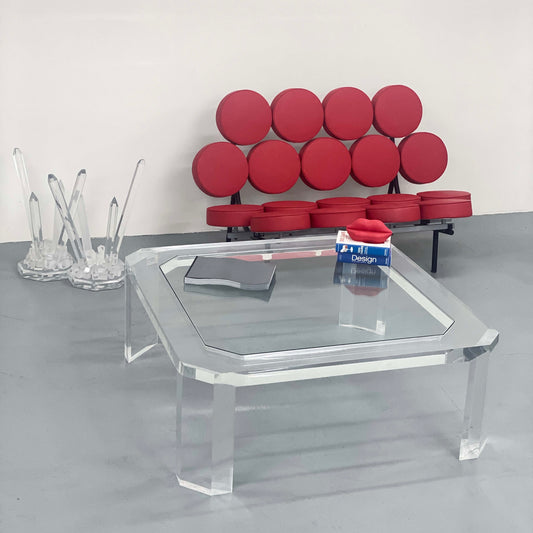 A glass coffee table with a red couch behind it in Portland Oregon